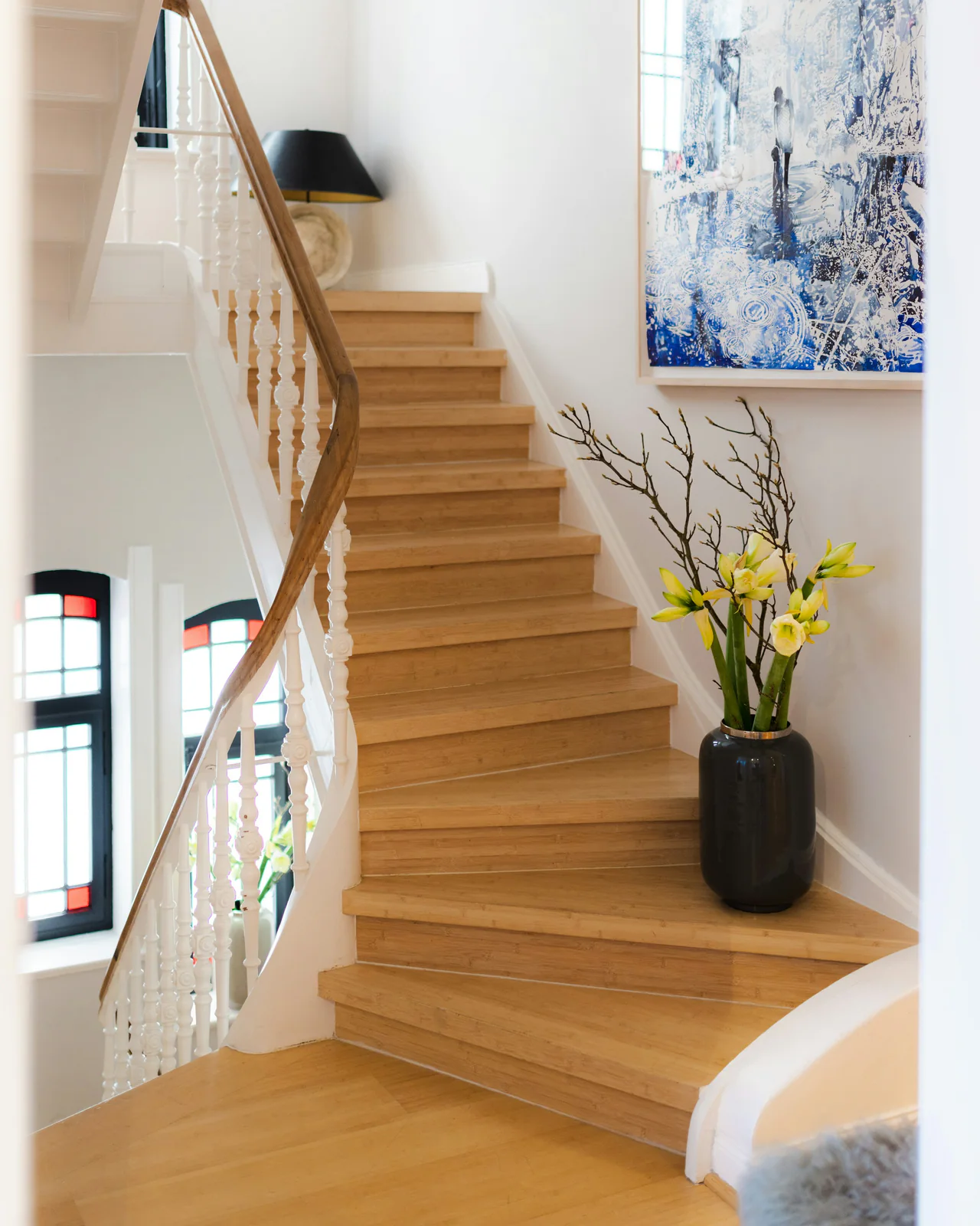 Eiken trap met witte balustrade en een vaas met gele bloemen
